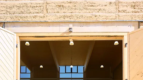 Ansicht von Außen nach Innen von der Stampflehmhalle Irrenhauser & Seitz