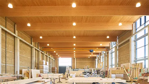 Innenansicht mit Brettschichtholz-Bindern der Stampflehmhalle Irrenhauser & Seitz, Alberzell