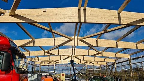 Frontale Ansicht der Montage des Holztragwerks der Lager- und Produktionshallen der Flachdach Solar GmbH + Co. KG